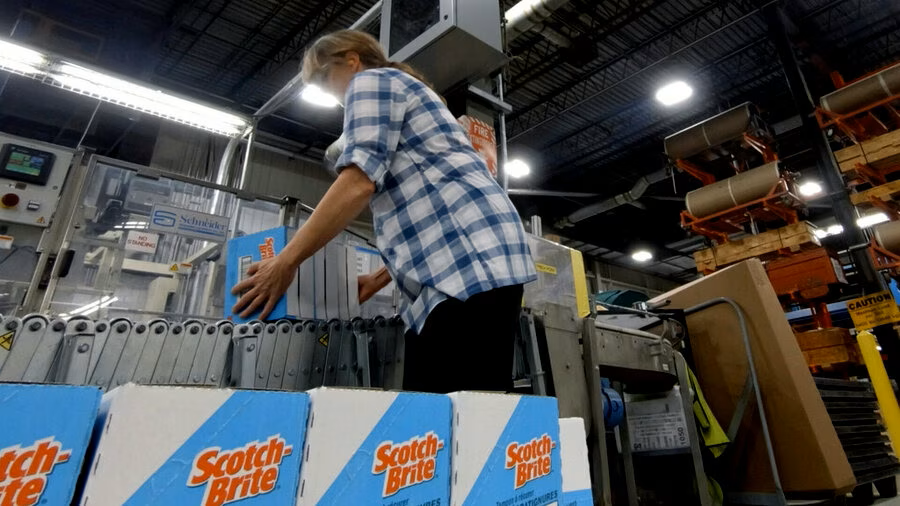 Female manufacturing employee stacking boxes of Scotch-Brite(TM) sponges.